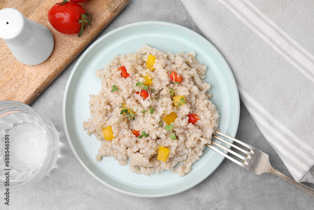 Delicious barley porridge with vegetables and microgreens on gray table, flat lay Delicious barley porridge with vegetables and microgreens on gray table, flat lay