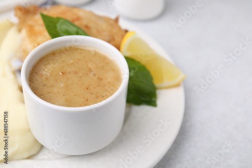 Delicious turkey gravy served on light grey table, closeup. Space for text