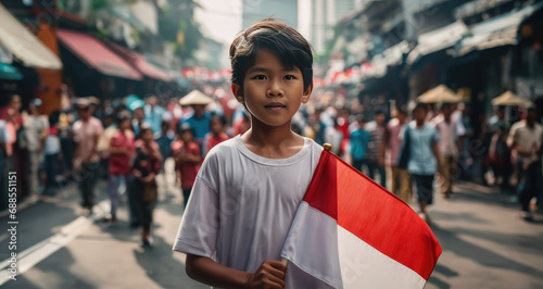 Indonesian boy holding Indonesia flag in Jakarta street 