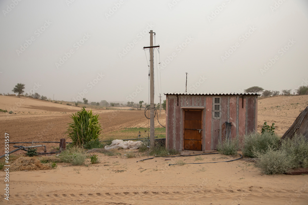 Small powerhouse and electricity pole and water tube well in desert farmland
