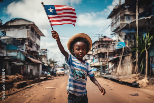 Liberian boy holding Liberia flag in Monrovia street photo