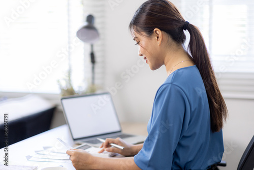 asian woman using calculator and calculate bills in home office. tax form us business income office Financial document. Tax time.Tax concept. photo
