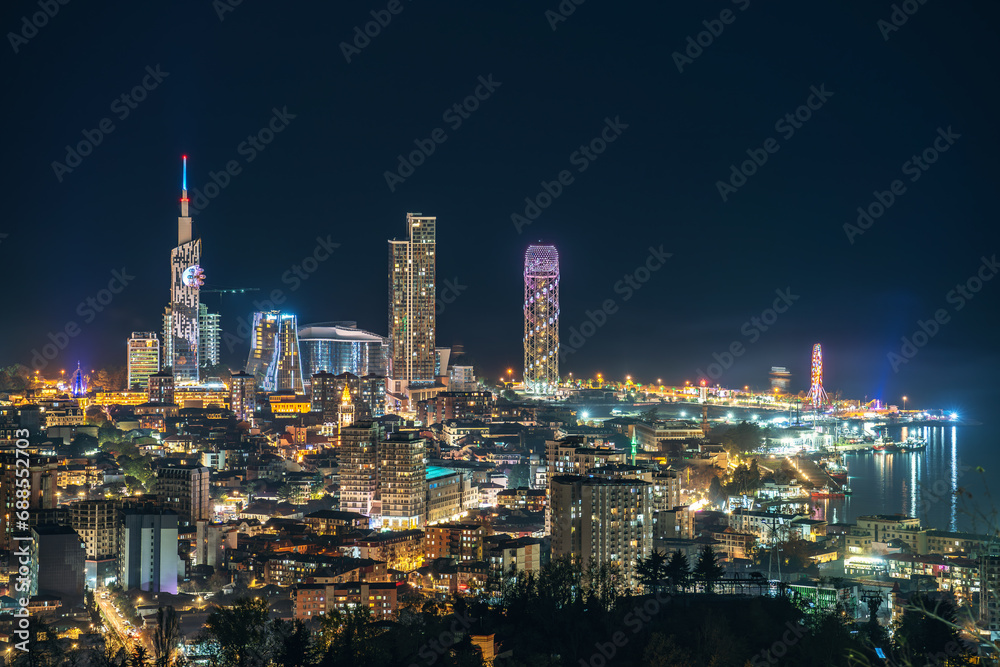 Night panorama of Batumi seaside, Georgia. Illuminated towers and buildings after sunset.