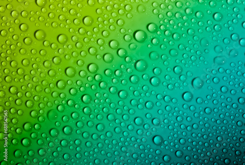 Water drops on glass as a background. Condensation on a cold drink. Green background with drops texture.