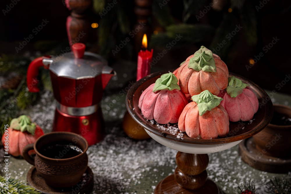 Homemade pink marshmallows in the shape of pumpkins surrounded by Christmas decorations. Homemade pink marshmallows in the shape of pumpkins surrounded by Christmas decorations.