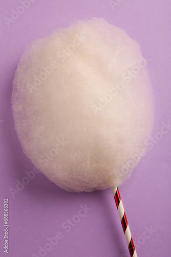 One sweet cotton candy on violet background, top view