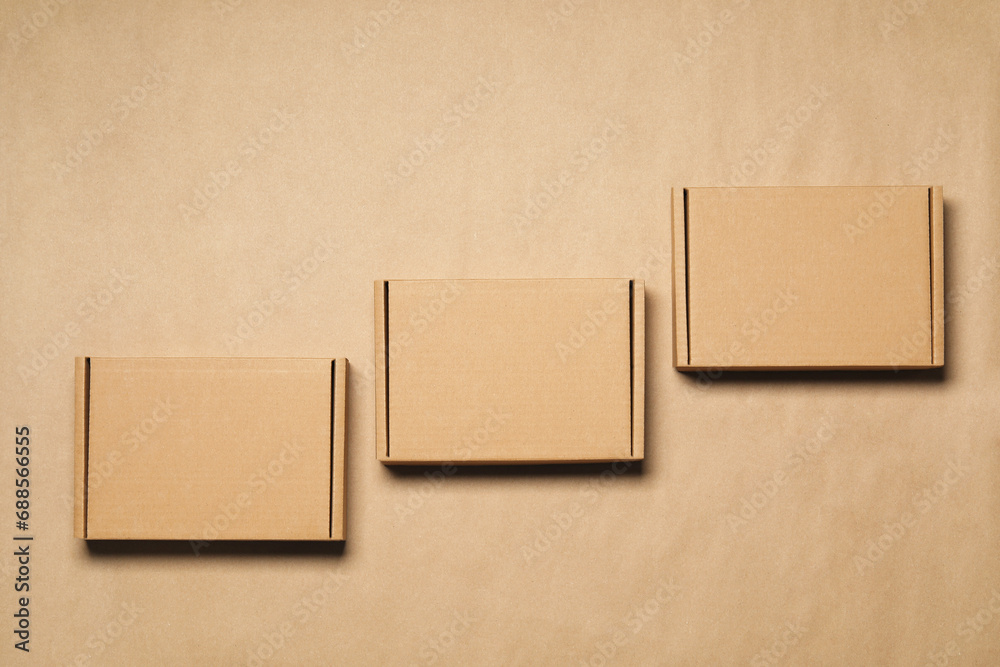 Closed cardboard boxes on light brown background, flat lay