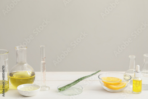 Developing cosmetic oil. Petri dish with aloe and laboratory dishware on white table, space for text