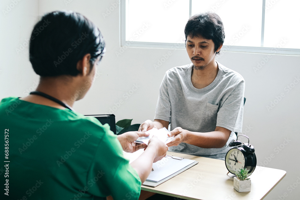 Sick male patient receiving presricption and medicine from the doctor. Healthcare and treatment concept Sick male patient receiving presricption and medicine from the doctor. Healthcare and treatment concept