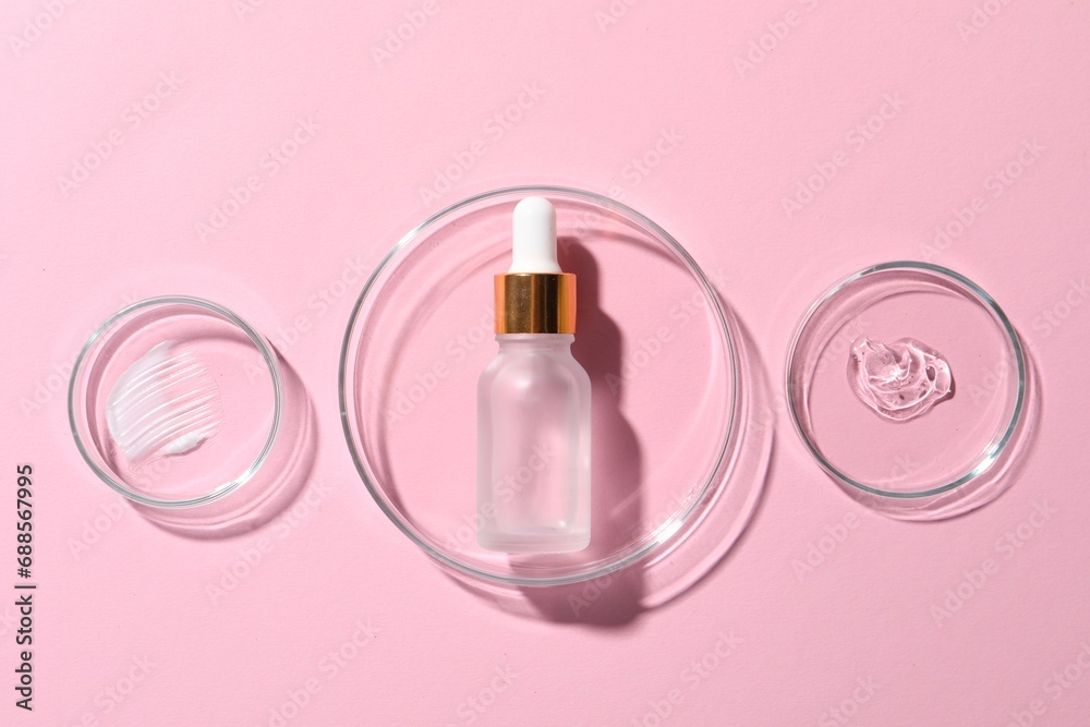 Bottle of cosmetic serum and petri dishes with samples on pink background, flat lay Bottle of cosmetic serum and petri dishes with samples on pink background, flat lay