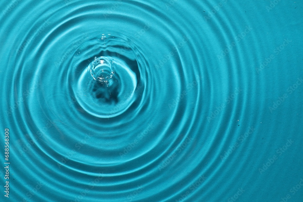 Rippled surface of clear water on light blue background, top view Rippled surface of clear water on light blue background, top view