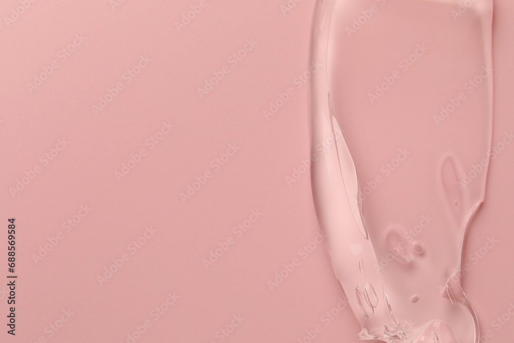 Sample of clear cosmetic gel on pink background, top view. Space for text