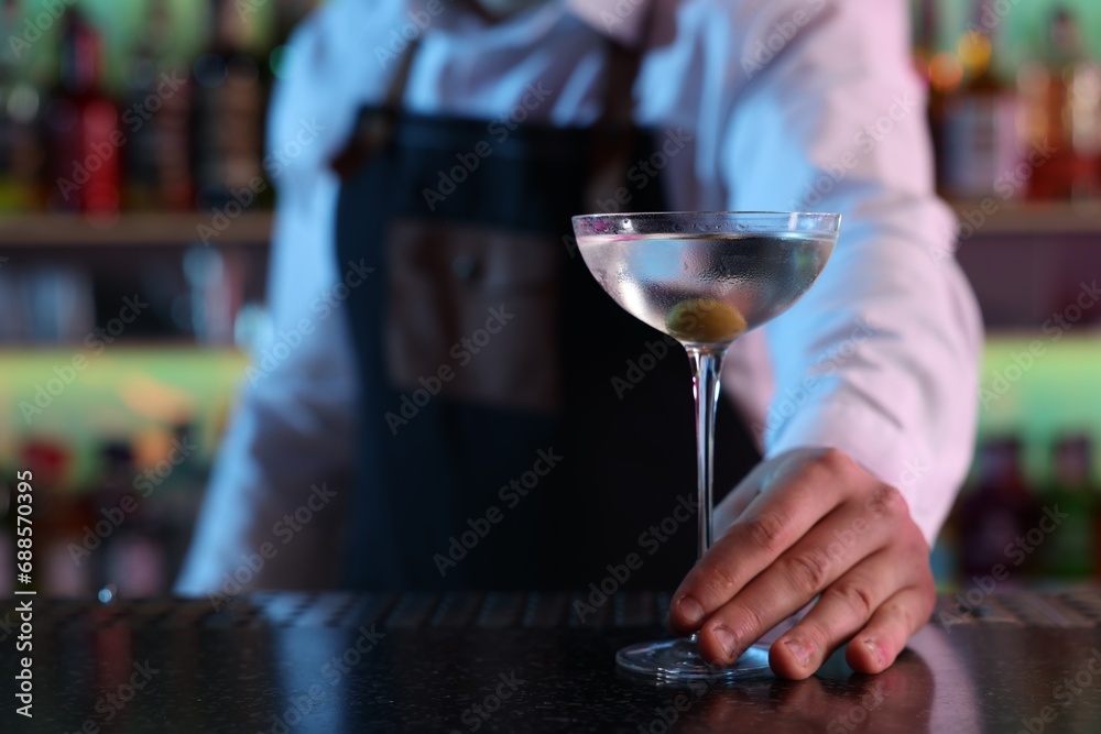 Bartender with fresh Martini cocktail at bar counter, closeup. Space for text