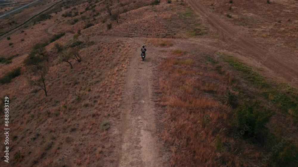 the drone following of a man riding an adventure-class motorcycle in a daytime. outdoor the drone following of a man riding an adventure-class motorcycle in a daytime. outdoor