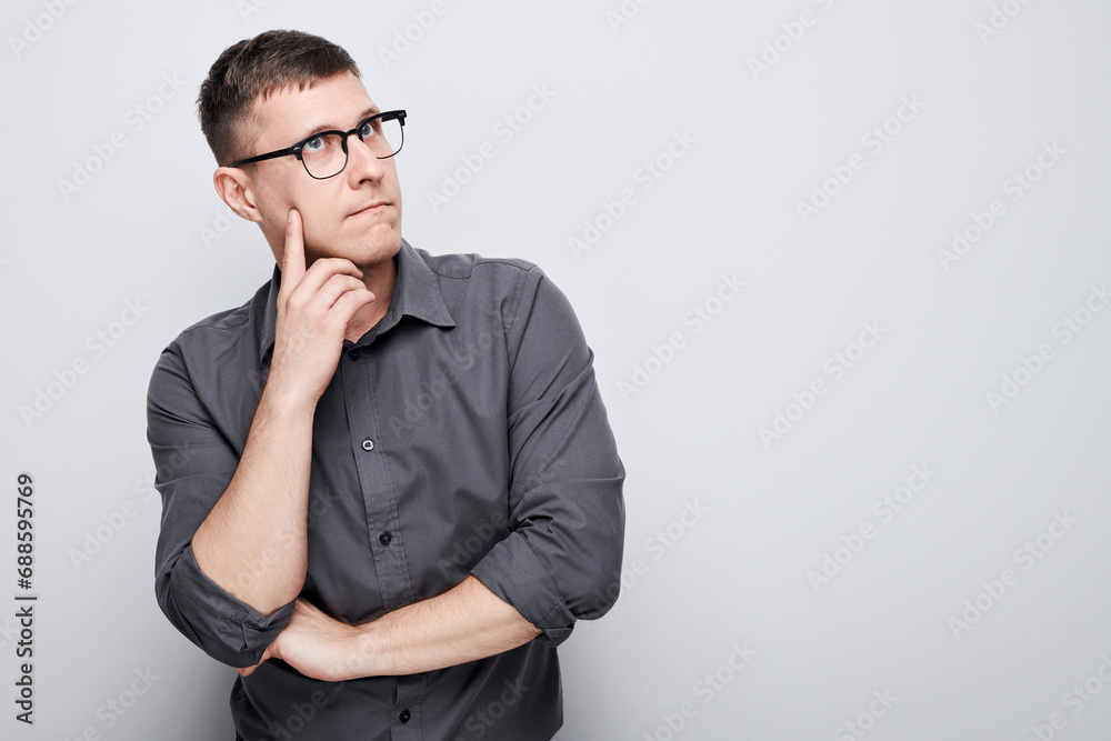 Portrait of clever man in shirt touching chin thinks doubts chooses isolated on white studio background with copy space Portrait of clever man in shirt touching chin thinks doubts chooses isolated on white studio background with copy space