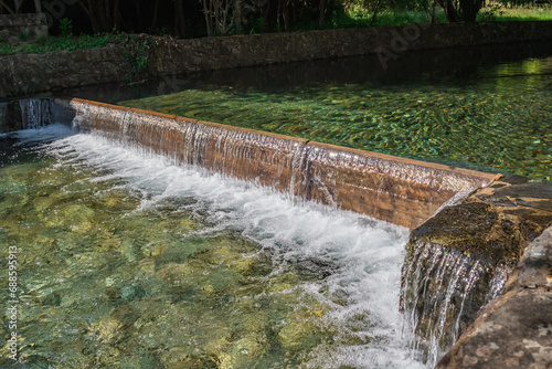 Small waterfall with movement and foam and sunlight in the pools of the river beach of Poço de Corga, Castanheira de Pêra PORTUGAL photo