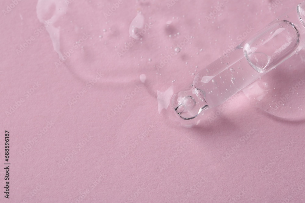 Pipette with cosmetic serum on pink background, above view. Space for text Pipette with cosmetic serum on pink background, above view. Space for text