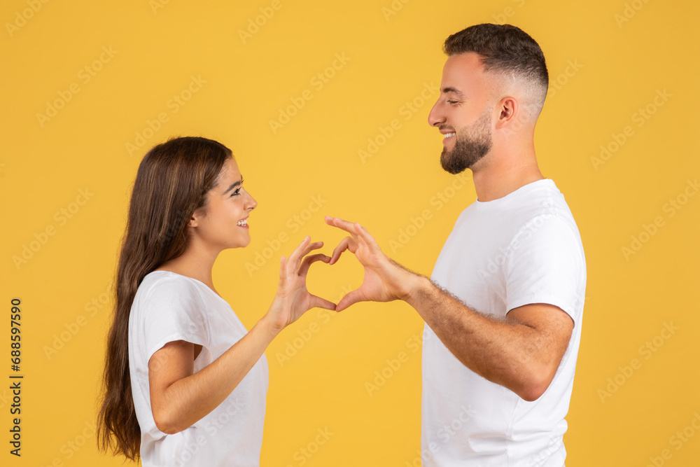 Satisfied millennial european wife and husband, making heart gesture with hands Satisfied millennial european wife and husband, making heart gesture with hands