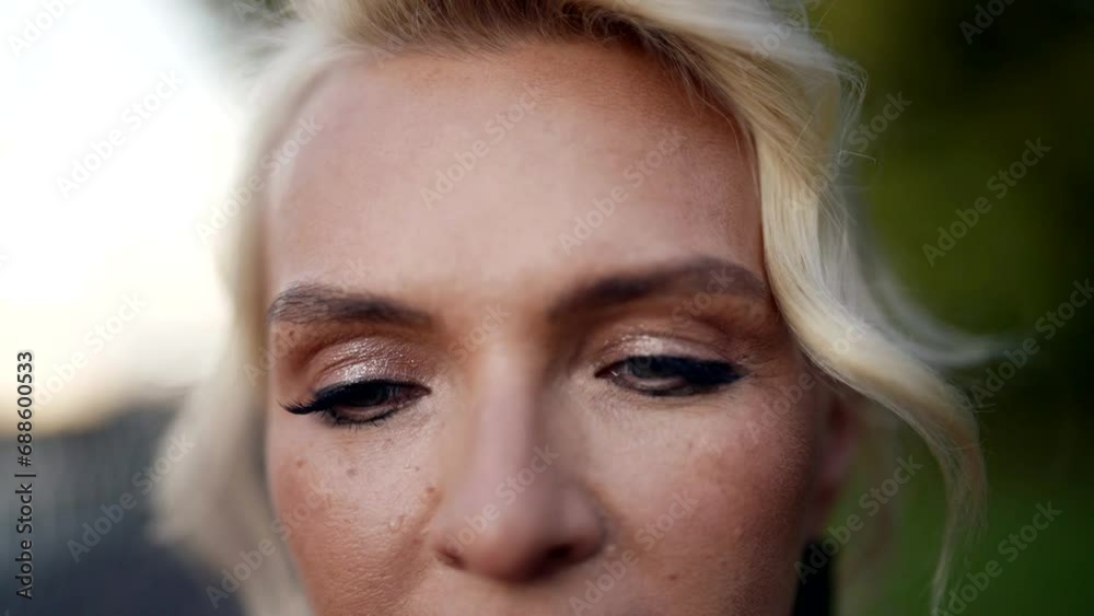 blonde woman looking at camera and crying, closeup view of face, tears on cheek and smeared mascara blonde woman looking at camera and crying, closeup view of face, tears on cheek and smeared mascara