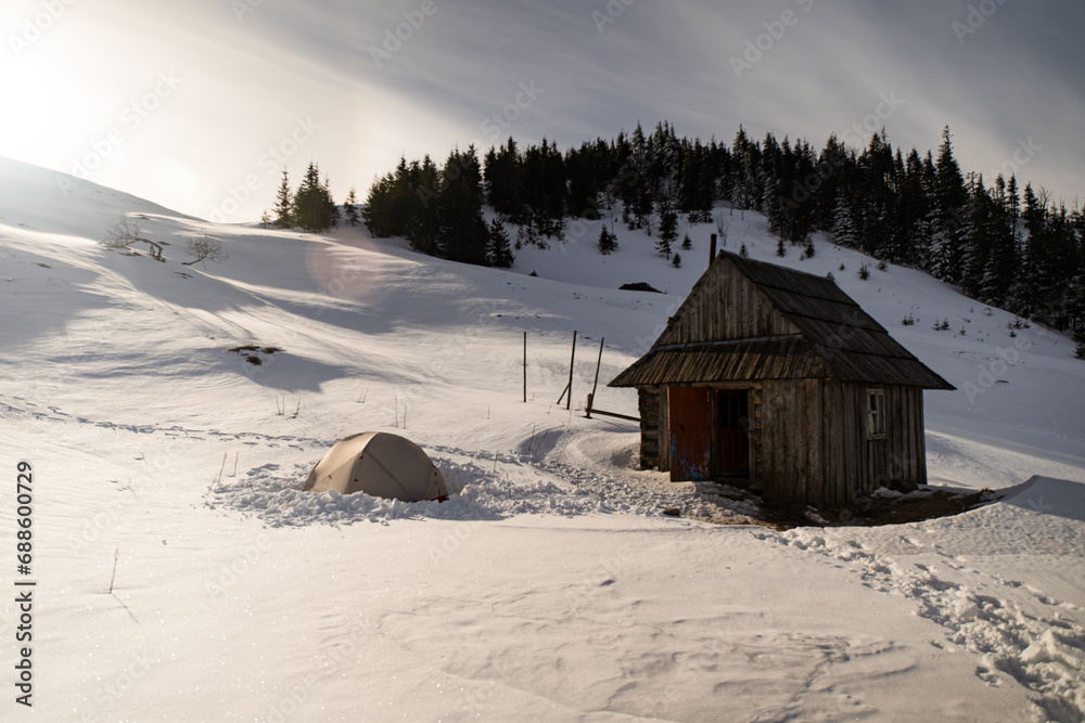 An old hut in mountains. Winter mountain range in Carpathian Mountain, Ukraine. Winter trekking An old hut in mountains. Winter mountain range in Carpathian Mountain, Ukraine. Winter trekking