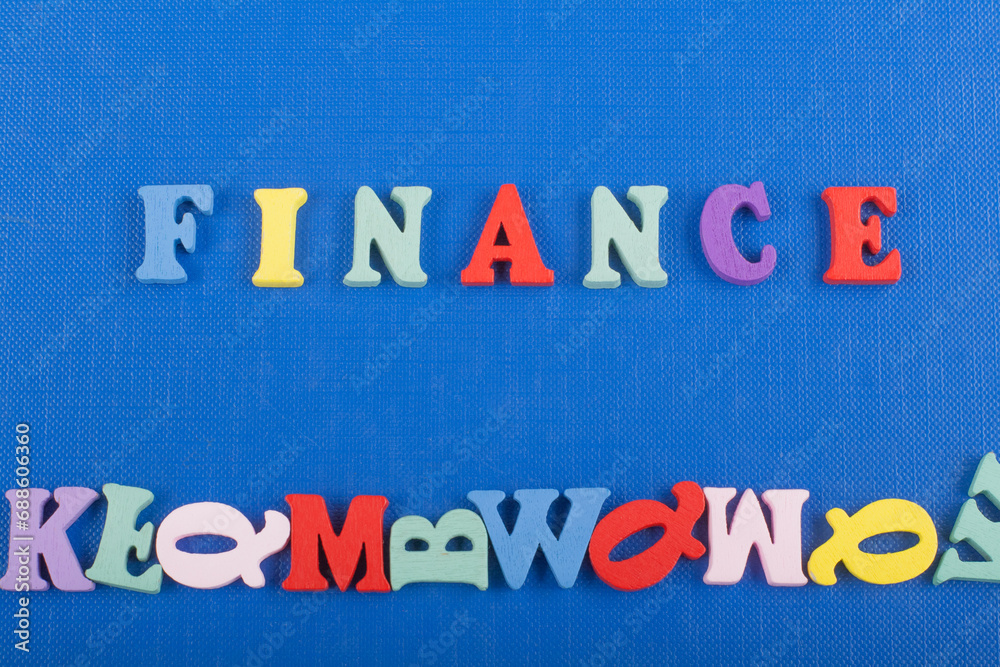 Fototapeta premium FINANCE word on blue background composed from colorful abc alphabet block wooden letters, copy space for ad text. Learning english concept.