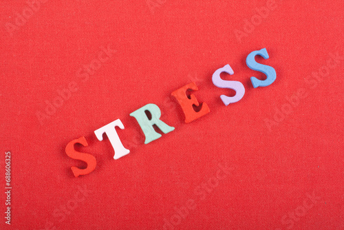 STRESS word on red background composed from colorful abc alphabet block wooden letters, copy space for ad text. Learning english concept.