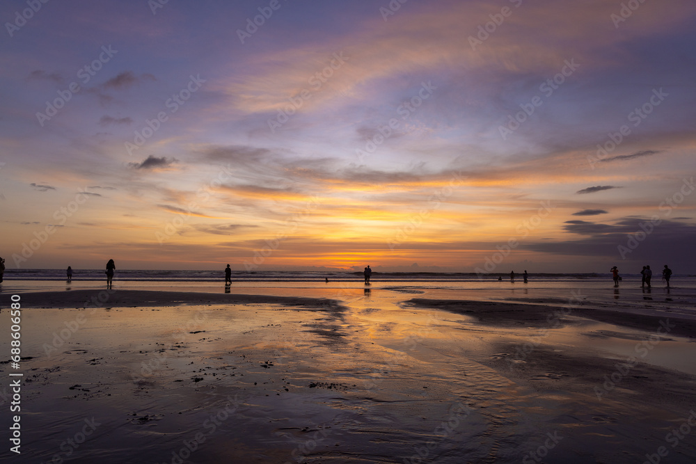 People on the beach in Seminyak at sunset, Bali Island, Indonesia People on the beach in Seminyak at sunset, Bali Island, Indonesia