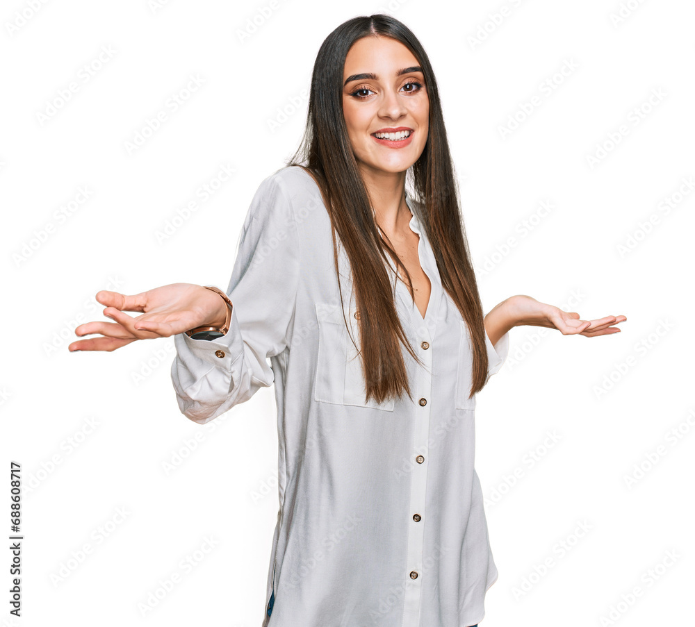 Young beautiful woman wearing casual white shirt smiling showing both hands open palms, presenting and advertising comparison and balance Young beautiful woman wearing casual white shirt smiling showing both hands open palms, presenting and advertising comparison and balance