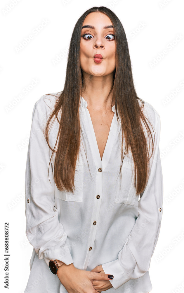 Young beautiful woman wearing casual white shirt making fish face with lips, crazy and comical gesture. funny expression. Young beautiful woman wearing casual white shirt making fish face with lips, crazy and comical gesture. funny expression.