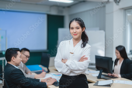 Happy confident smiling young professional Asian business woman corporate leader, Japanese female employee or company sales marketing manager standing arms crossed in office, cute girl portrait © chokniti