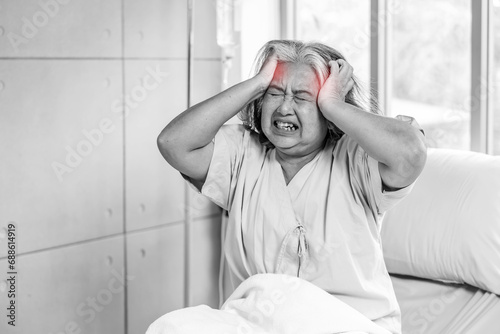 Elderly asian woman sitting on bed suffering from headache and migraine so pain and illness, Stress senior woman sit on bed at hospital or clinic alone, tried, Unhappy Elderly despond concept photo