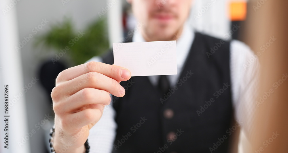 Male hand in suit give blank calling card to female visitor closeup. White collar partners company name exchange executive or ceo introducing at conference product consultant sale clerk concept Male hand in suit give blank calling card to female visitor closeup. White collar partners company name exchange executive or ceo introducing at conference product consultant sale clerk concept