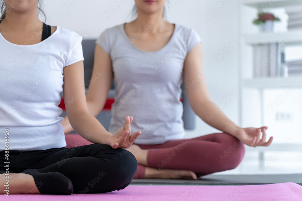 Two women sitting on yoga mat