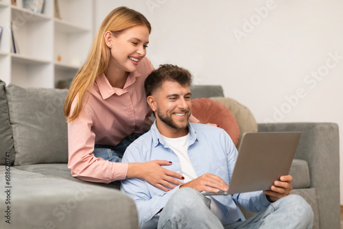 couple browsing websites and watching movies on laptop at home