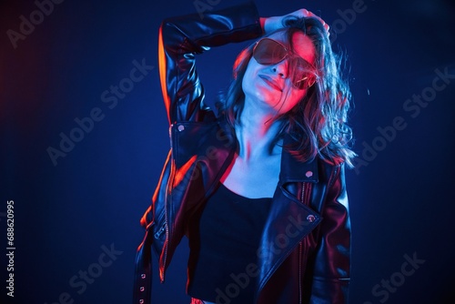 In sunglasses. Cool young woman portrait in neon colors
