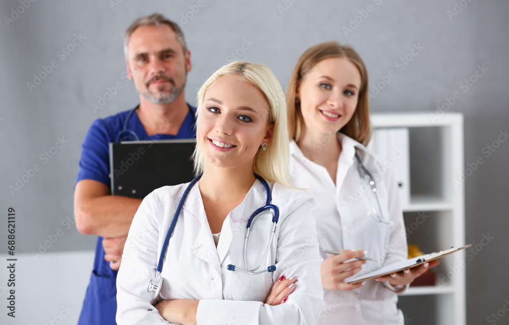 Beautiful smiling female doctor stand in office portrait. Physical and patient disease prevention exam er ward round 911 prescribe remedy healthy lifestyle consultant nurse profession concept Beautiful smiling female doctor stand in office portrait. Physical and patient disease prevention exam er ward round 911 prescribe remedy healthy lifestyle consultant nurse profession concept