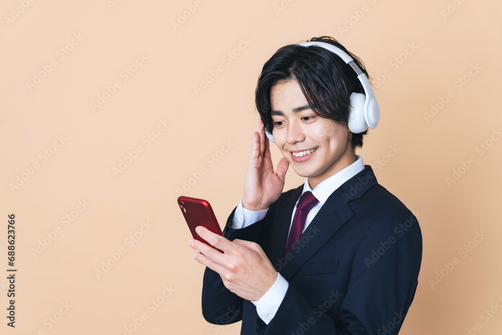 ヘッドホンとスマホで音楽を聴く男性 ヘッドホンとスマホで音楽を聴く男性