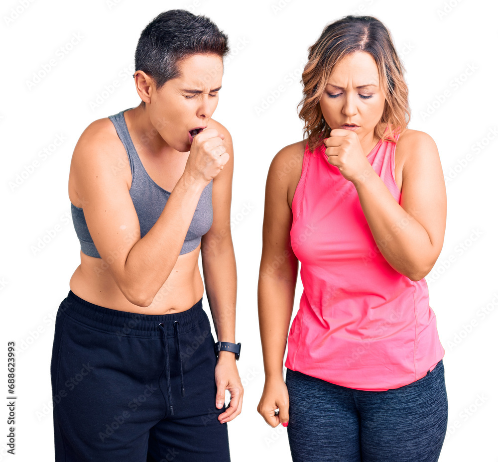 Couple of women wearing sportswear feeling unwell and coughing as symptom for cold or bronchitis. health care concept. Couple of women wearing sportswear feeling unwell and coughing as symptom for cold or bronchitis. health care concept.