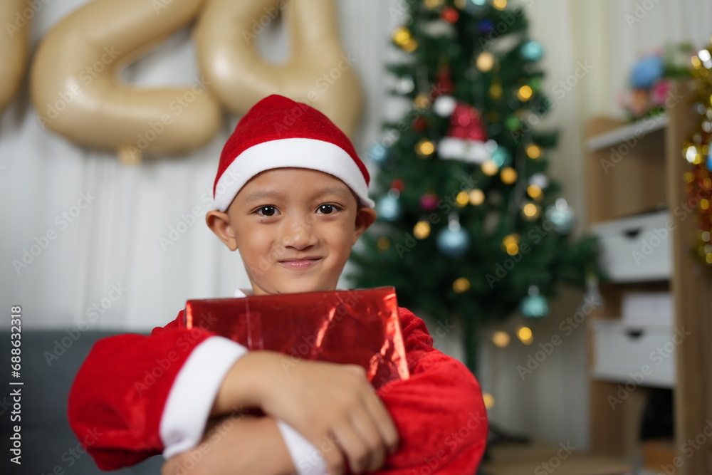 Merry Christmas 2024 concept Boy receives a gift from his mother at christmas Merry Christmas 2024 concept Boy receives a gift from his mother at christmas
