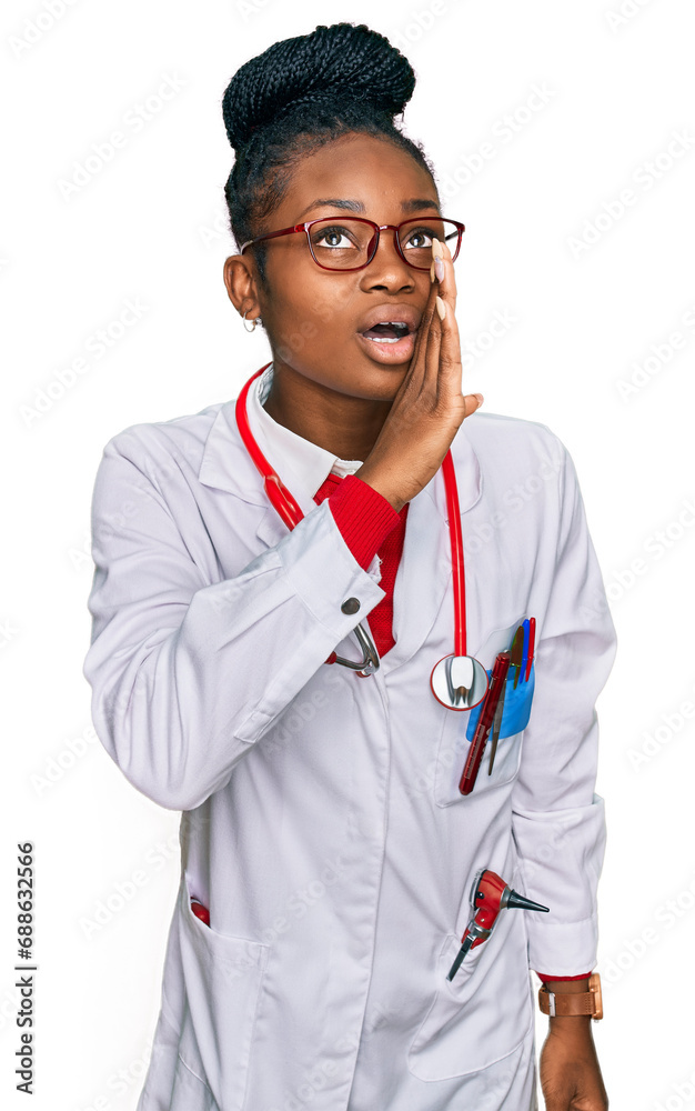 Young african american woman wearing doctor uniform and stethoscope hand on mouth telling secret rumor, whispering malicious talk conversation Young african american woman wearing doctor uniform and stethoscope hand on mouth telling secret rumor, whispering malicious talk conversation