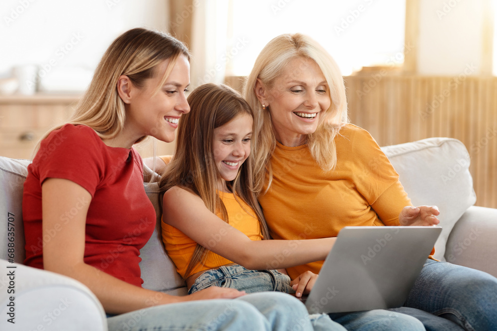 Three generations women family using laptop at home Three generations women family using laptop at home