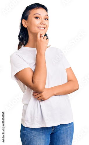 Young woman wearing casual clothes looking confident at the camera with smile with crossed arms and hand raised on chin. thinking positive.