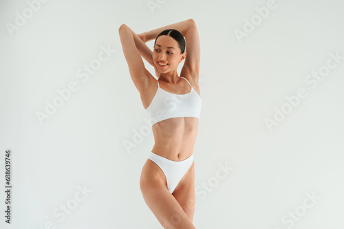 Weight loss conception. Woman in white underwear with slim body type against white background