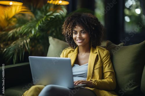 Portrait of a smiling African American female freelancer working on a laptop.