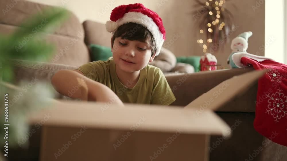 Kid boy decorating Christmas tree put off balls from the box authentic real celebration image lifestyle. Xmas with family children fun at cozy home Kid boy decorating Christmas tree put off balls from the box authentic real celebration image lifestyle. Xmas with family children fun at cozy home