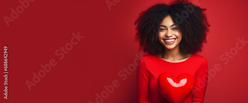 Happy, elegant, laughing, carefree girl African American dark-skinned, woman with heart on red background for Valentine's day, banner, advertisement.