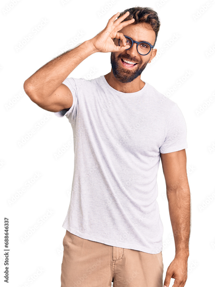 Young hispanic man wearing casual clothes and glasses doing ok gesture with hand smiling, eye looking through fingers with happy face. Young hispanic man wearing casual clothes and glasses doing ok gesture with hand smiling, eye looking through fingers with happy face.
