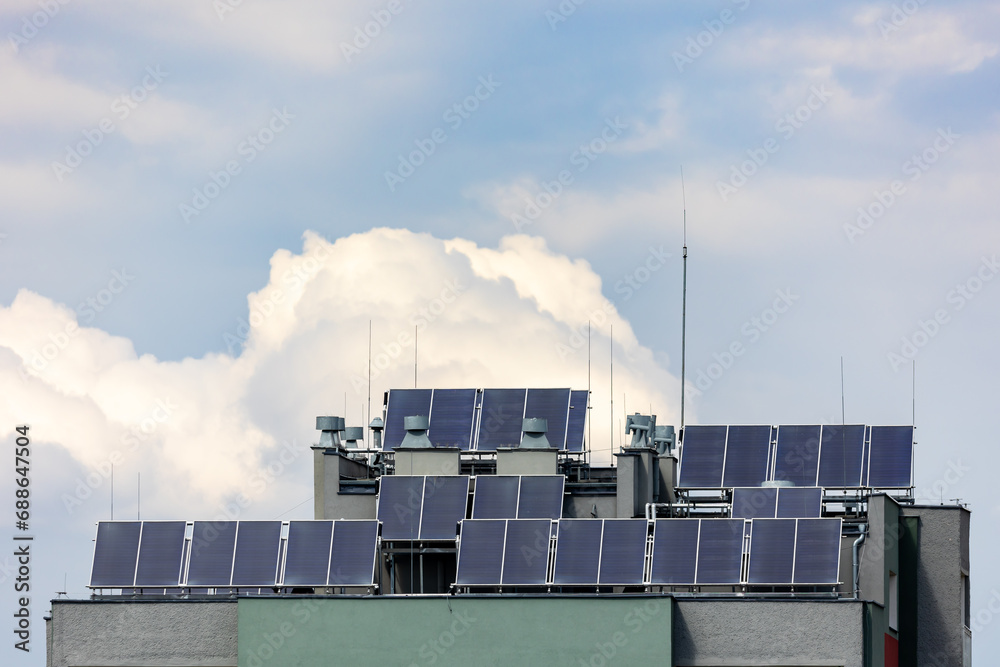 Photovoltaic, solar panels on the roof of a residential block. Production of electricity by prosumers using solar energy. Photo taken during the day, natural lighting conditions