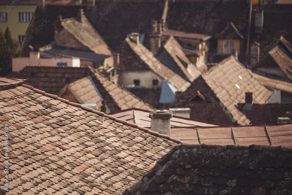 Scenic view of traditional romanian tile roofs of houses in the Old Town of Sighisoara. old town roofs with cimneys. View of the town from the hill. 