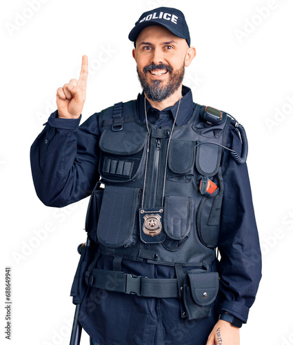Young handsome man wearing police uniform pointing finger up with successful idea. exited and happy. number one.